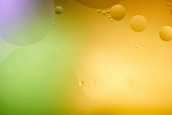 Beautiful abstract background from mixed water and oil in orange, purple and green color — Stock Photo