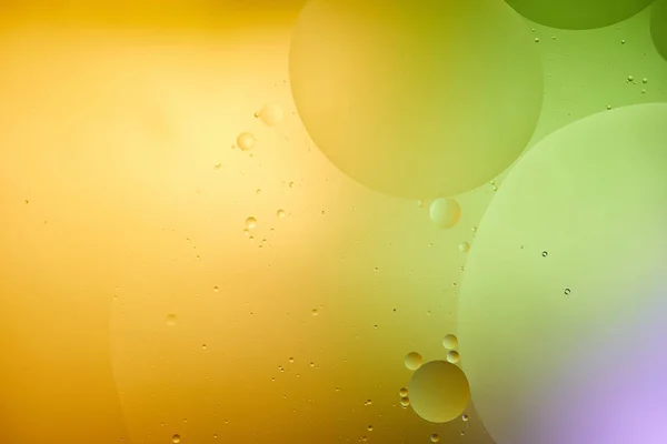 Beautiful abstract background from mixed water and oil in purple, orange and green color — Stock Photo