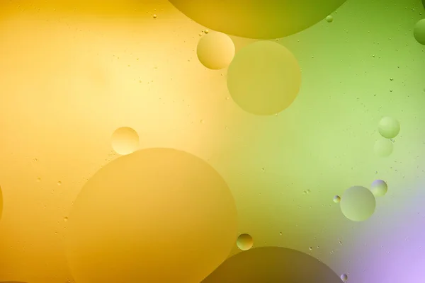 Abstract background from mixed water and oil in orange, purple and green color — Stock Photo