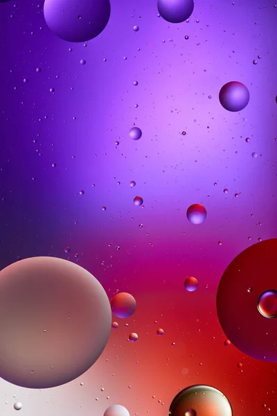 Креативна абстрактна фіолетова та червона кольорова текстура зі змішаної води та олійних бульбашок — стокове фото