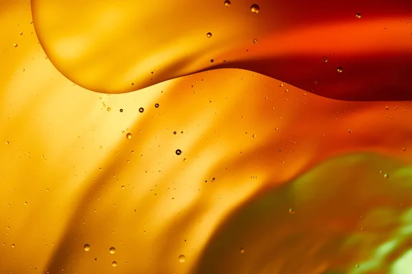 Beautiful abstract background from mixed water and oil in orange, red and green color — Stock Photo