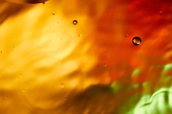 Schöne abstrakte orange, rote und grüne Farbe Hintergrund aus gemischtem Wasser und Öl — Stockfoto