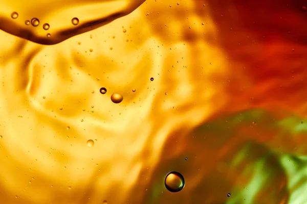 Bellissimo sfondo astratto da acqua mista e olio in colore arancione, rosso e verde — Foto stock