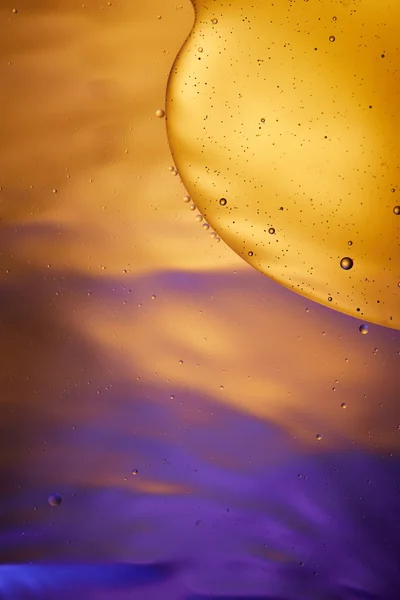 Beau fond abstrait de mélange d'eau et d'huile de couleur orange et violette — Photo de stock