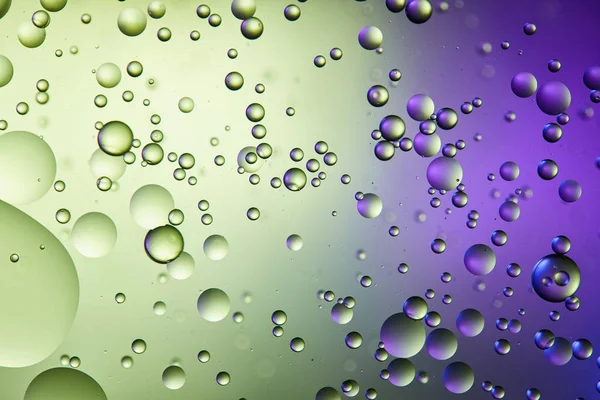 Astratto sfondo di colore viola e verde da acqua mista e bolle d'olio — Foto stock