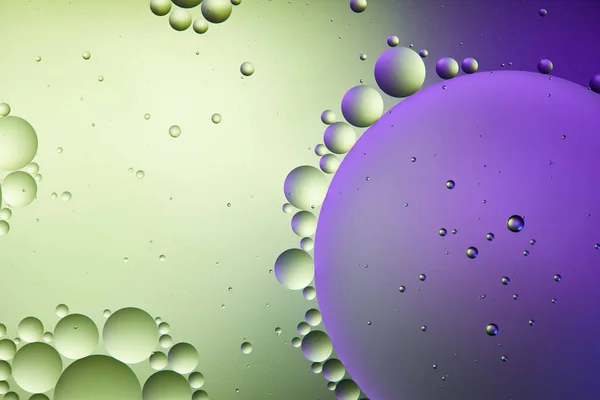 Astratto sfondo di colore viola e verde da acqua mista e bolle d'olio — Foto stock