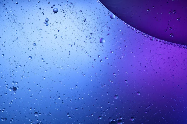 Creative background from mixed water and oil in blue and purple color — Stock Photo