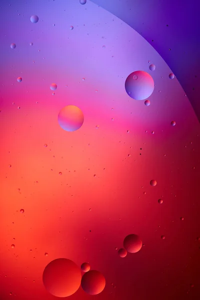 Креативная текстура из смешанной воды и масляных пузырей розового и фиолетового цвета — стоковое фото