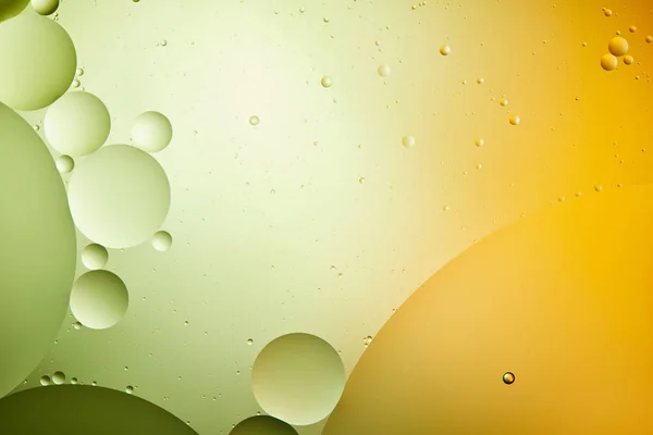 Macro sfondo astratto da acqua mista e olio in colore verde e arancione — Foto stock