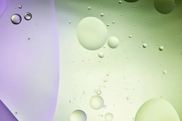 Bellissimo sfondo astratto da acqua mista e olio in colore verde chiaro e viola — Foto stock