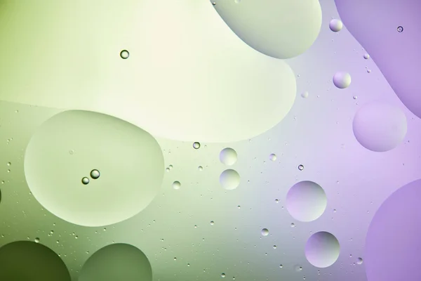 Abstract background from mixed water and oil in light green and purple color — Stock Photo