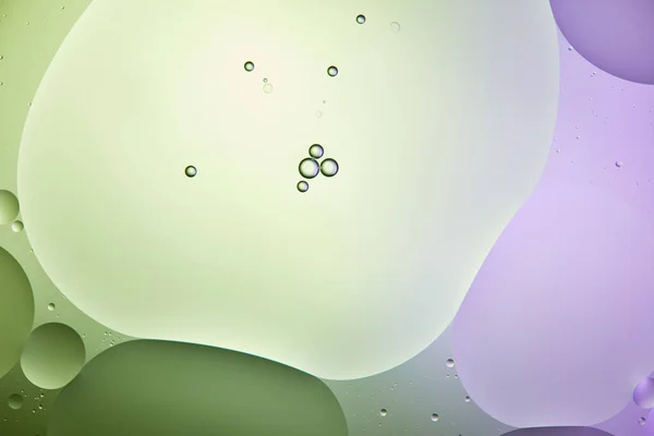 Эффектный фон из смешанной воды и масла в светло-зеленый и фиолетовый цвет — стоковое фото