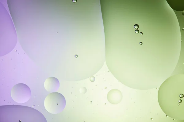 Sfondo astratto da acqua mista e olio in colore verde chiaro e viola — Foto stock