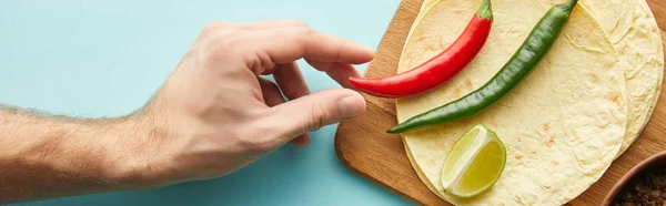 Abgeschnittene Ansicht eines Mannes mit Chilischote mit Tortillas und Limettenscheibe auf blauem Hintergrund, Panoramaaufnahme — Stockfoto