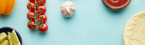 Top view of tortillas with ripe vegetables and lime on blue background, panoramic shot — Stock Photo