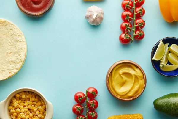 Top view of organic ingredients with fresh tortillas on blue background — Stock Photo