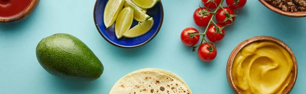 Top view of tortillas with fresh ingredients for taco on blue background, panoramic shot — Stock Photo