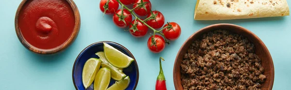 Vista dall'alto di salsa di pomodoro, carne macinata e tortilla su sfondo blu, panoramica — Foto stock