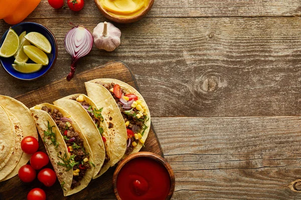 Vista dall'alto di tacos preparati con tortillas e verdure su sfondo di legno con spazio copia — Foto stock