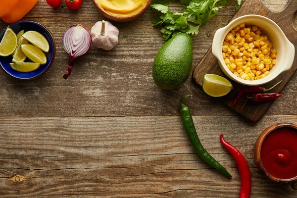 Top view of fresh vegetables, fruits and sauces on wooden surface with copy space — Stock Photo