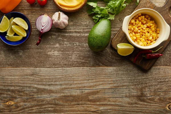 Вид зверху на сирі овочі та фрукти з зеленню на дерев'яній поверхні — стокове фото
