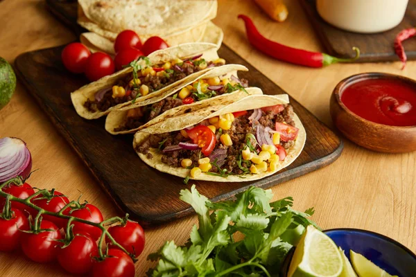 Tacos mexicanos tradicionais com legumes e salsa na mesa de madeira — Fotografia de Stock