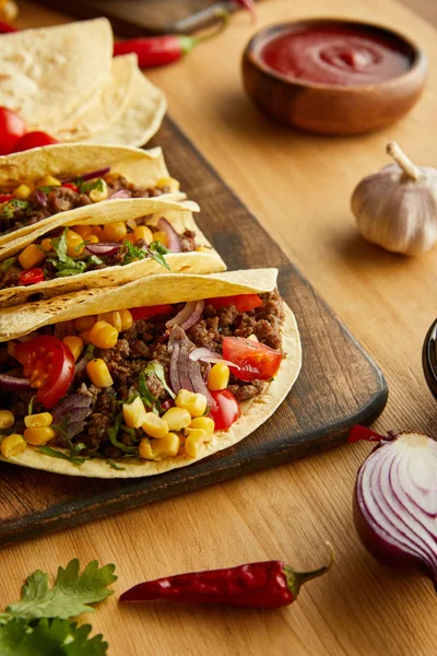 Delicious tacos with meat and vegetables on wooden table — Stock Photo