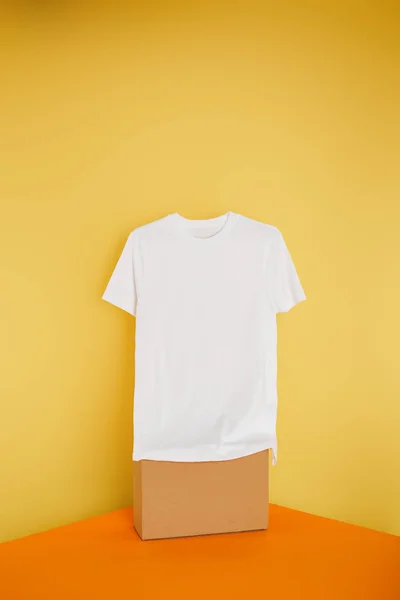T-shirt blanc basique sur cube sur fond jaune — Photo de stock