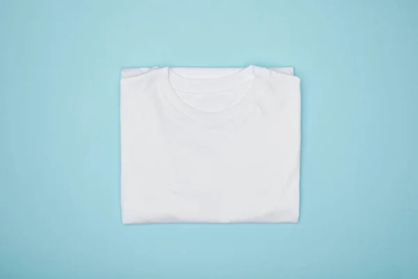 Top view of blank basic white t-shirt isolated on blue — Stock Photo