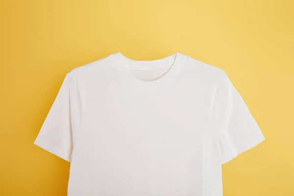 Vista superior da camiseta branca básica no fundo amarelo — Fotografia de Stock