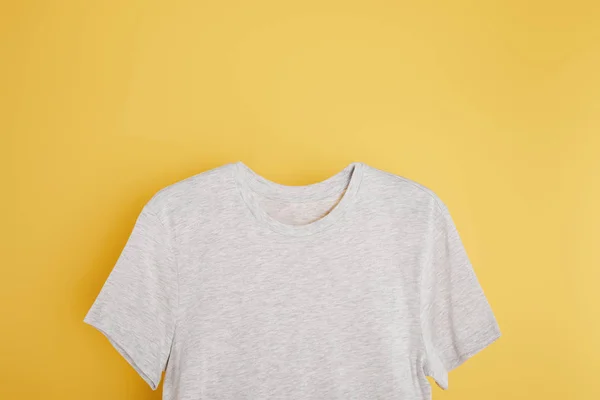 Vue du dessus du t-shirt gris basique sur fond jaune — Photo de stock