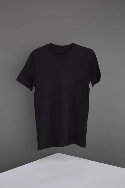 Basica t-shirt nera su fondo grigio — Foto stock