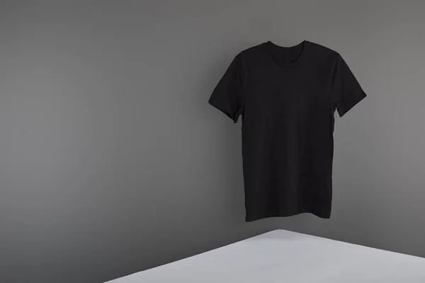 Branco básico preto t-shirt no fundo cinza — Fotografia de Stock