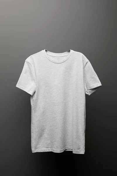 Blank basic light grey t-shirt on grey background — Stock Photo