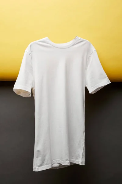 T-shirt blanc de base vierge sur fond noir et jaune — Photo de stock
