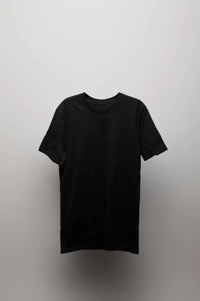 Branco básico preto t-shirt no fundo cinza — Fotografia de Stock