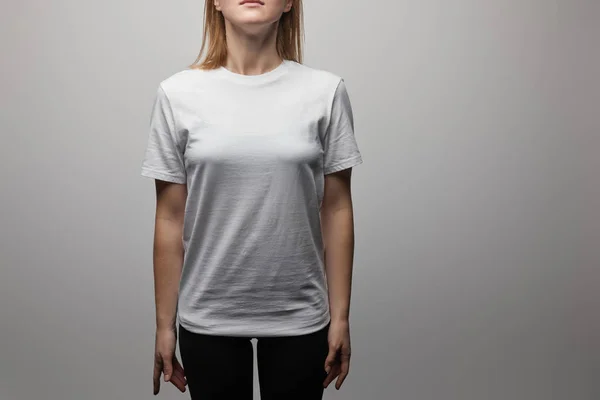 Vista ritagliata della donna in bianco bianco di base t-shirt su sfondo grigio — Foto stock