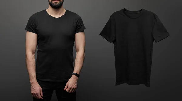 Vue recadrée de l'homme barbu près de blanc t-shirt noir de base sur fond noir — Photo de stock