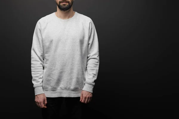 Vista recortada del hombre barbudo en sudadera gris básica en blanco aislada en negro - foto de stock