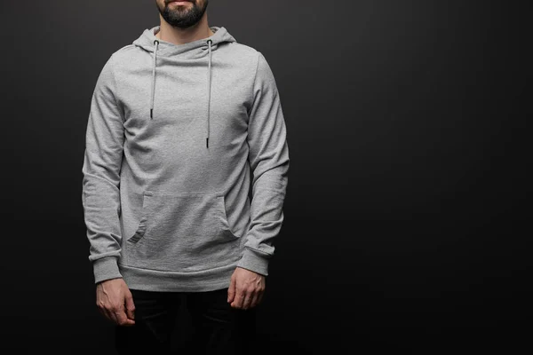 Cropped view of bearded man in blank basic grey hoodie isolated on black background — Stock Photo