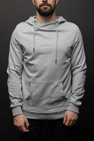 Cropped view of bearded man in blank basic grey hoodie isolated on black background — Stock Photo