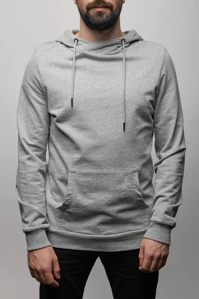 Cropped view of bearded man in blank basic grey hoodie isolated on grey — Stock Photo