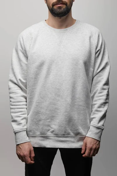 Vista ritagliata di uomo barbuto in bianco felpa grigio di base isolato su grigio — Foto stock