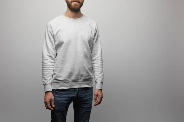 Visão parcial do homem barbudo em branco camisola cinza básico isolado em cinza — Fotografia de Stock