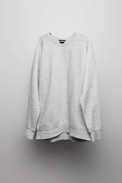 Sudadera gris básica en blanco sobre fondo gris - foto de stock