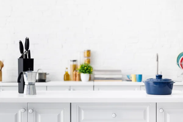 Interior da cozinha branca moderna com panela de café, panela e facas na mesa — Fotografia de Stock