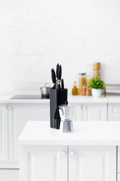 Intérieur moderne de cuisine blanche avec cafetière et couteaux sur la table — Photo de stock