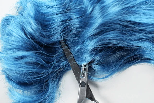Draufsicht auf blaues Haar und Schere auf weißem Hintergrund — Stockfoto