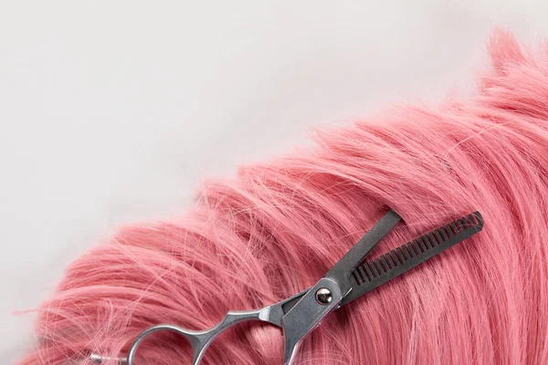 Vue de dessus des ciseaux sur cheveux roses isolés sur blanc — Photo de stock