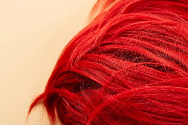 Vue du dessus des cheveux de couleur rouge sur fond beige — Photo de stock